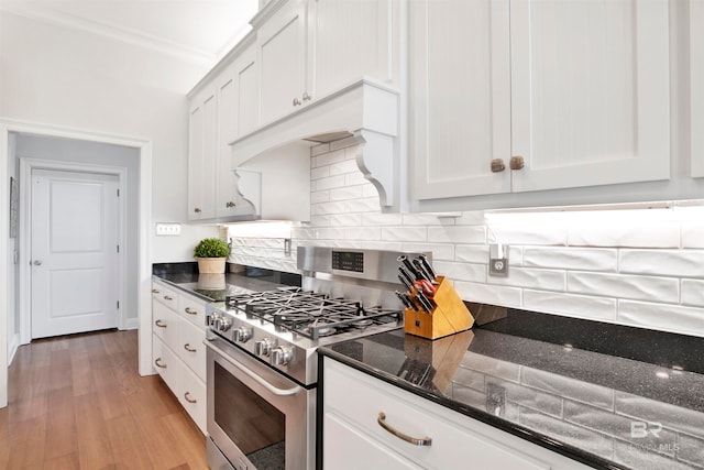 kitchen featuring white cabinetry, light hardwood / wood-style flooring, stainless steel stove, and crown molding