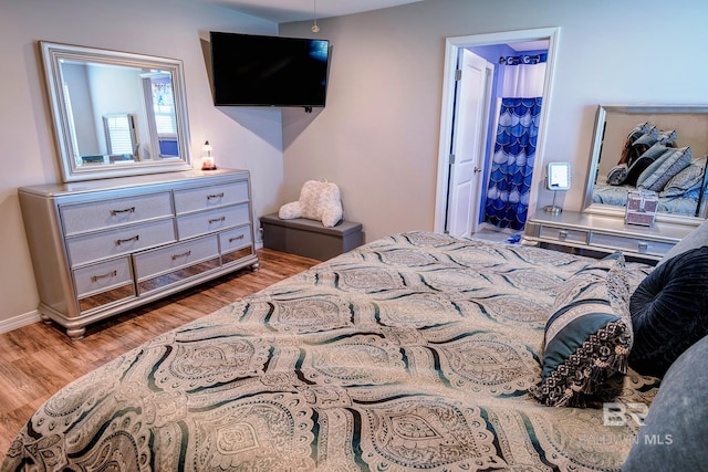 bedroom with baseboards and wood finished floors