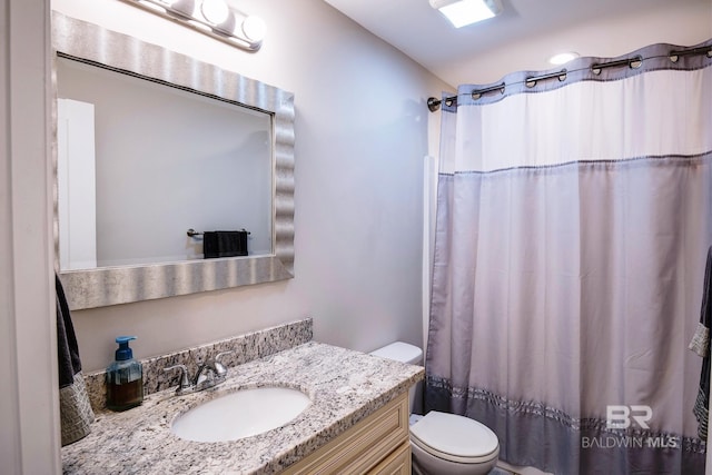 full bath with a shower with curtain, toilet, and vanity