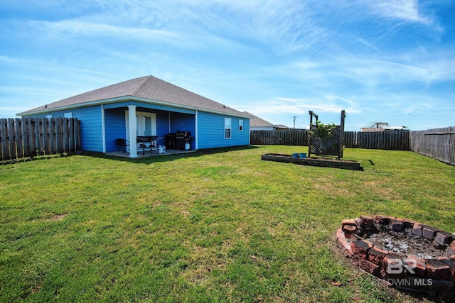 view of yard with a fenced backyard, a fire pit, and a patio