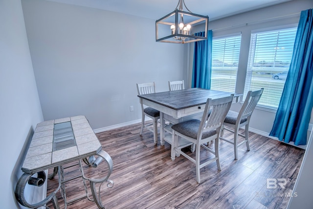 dining space with wood finished floors, a notable chandelier, and a wealth of natural light