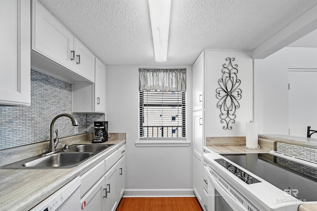 kitchen featuring tasteful backsplash, sink, white cabinets, and white dishwasher