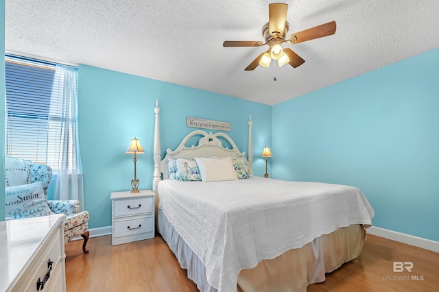 bedroom featuring a textured ceiling, light hardwood / wood-style floors, and ceiling fan