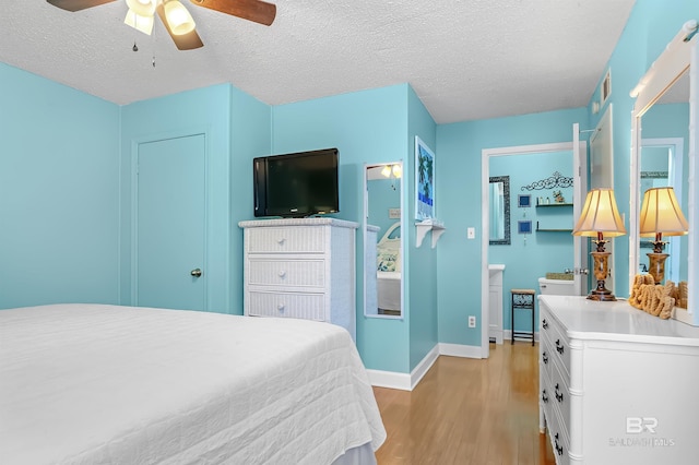 bedroom with ceiling fan, a textured ceiling, and light wood-type flooring