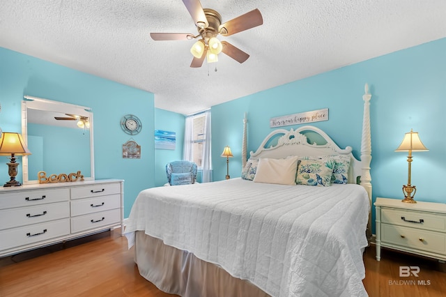 bedroom with wood-type flooring, a textured ceiling, and ceiling fan