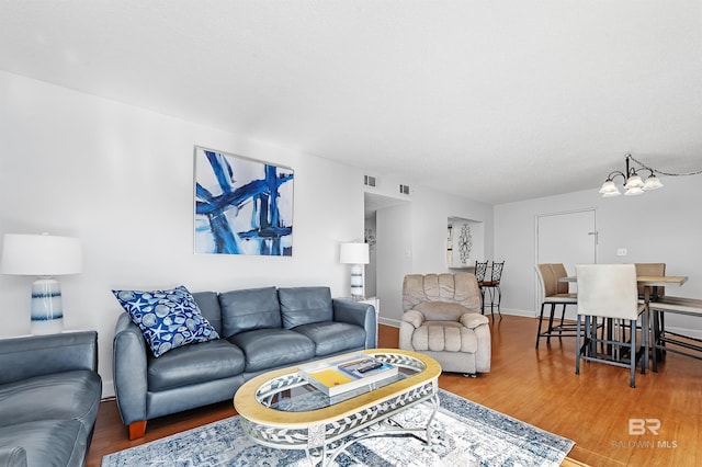 living room featuring a chandelier and wood-type flooring