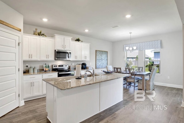 11569 Thistledown Loop, Spanish Fort, AL 36527 - kitchen featuring stainless steel appliances, a sink, white cabinets, wood finished floors, and recessed lighting