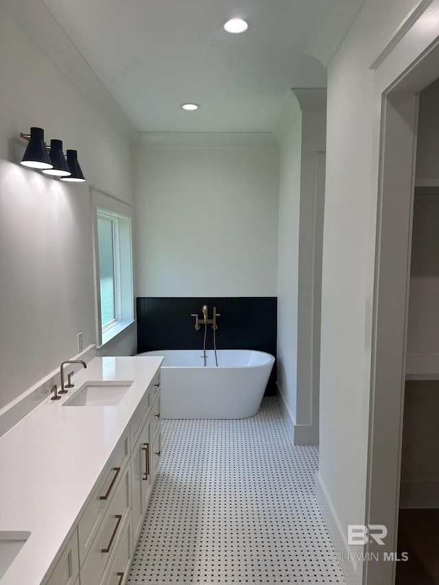 bathroom featuring a bathtub, ornamental molding, and vanity