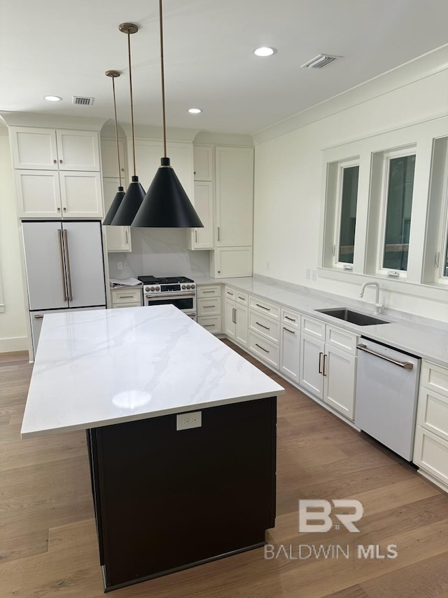 kitchen with pendant lighting, a center island, light hardwood / wood-style flooring, and stainless steel appliances