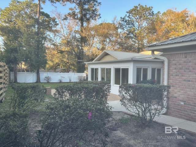 view of side of home with fence and brick siding