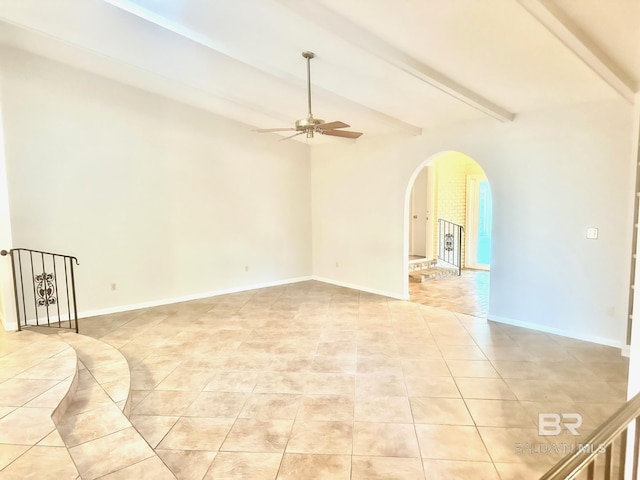 unfurnished room featuring baseboards, beam ceiling, light tile patterned flooring, arched walkways, and ceiling fan