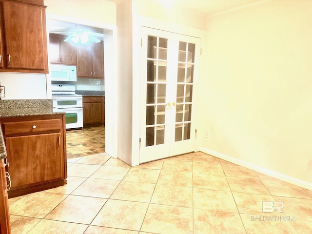 kitchen with white appliances, light tile patterned flooring, french doors, crown molding, and brown cabinets