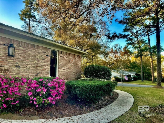 view of side of home featuring a yard and brick siding