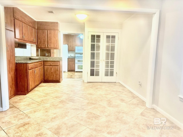 kitchen featuring white appliances, french doors, brown cabinets, and visible vents