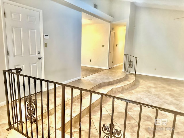 corridor featuring tile patterned floors, visible vents, and baseboards