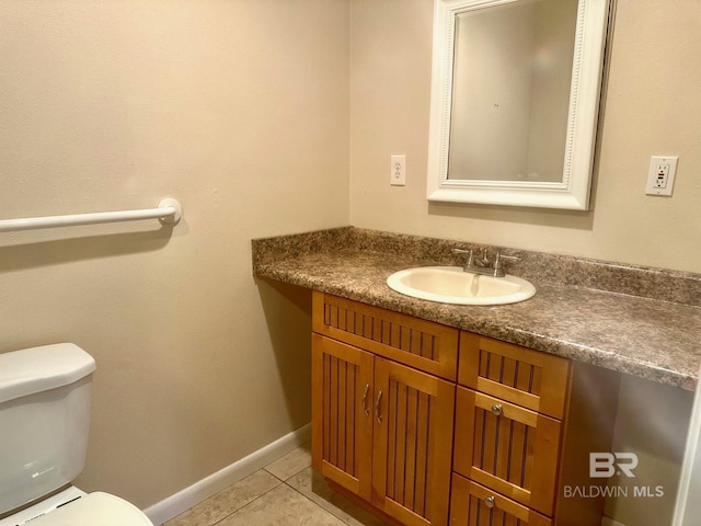 half bathroom featuring vanity, tile patterned floors, toilet, and baseboards