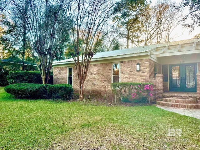 exterior space featuring french doors, metal roof, and a yard