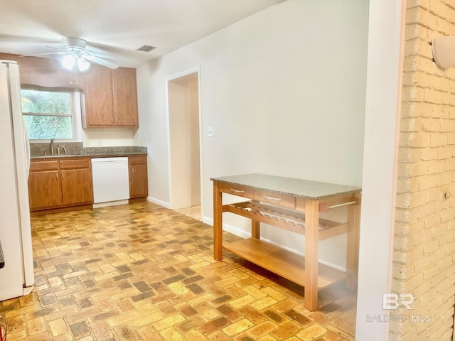 kitchen with visible vents, a ceiling fan, a sink, white appliances, and baseboards