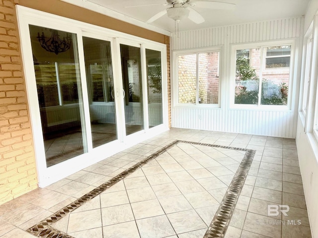 unfurnished sunroom featuring a ceiling fan