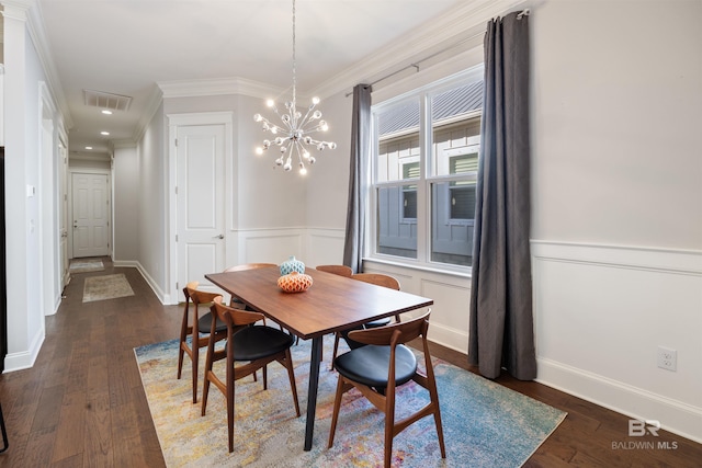 dining space with ornamental molding, a chandelier, and dark hardwood / wood-style flooring