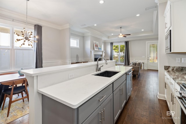 kitchen with pendant lighting, dark hardwood / wood-style flooring, sink, appliances with stainless steel finishes, and white cabinetry