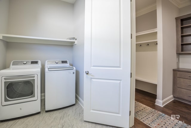 laundry room with crown molding, washer and clothes dryer, and light hardwood / wood-style flooring