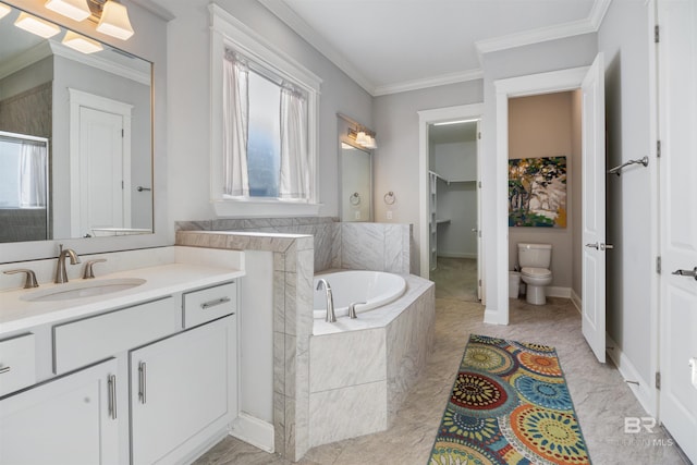 bathroom with tiled tub, crown molding, vanity, and toilet