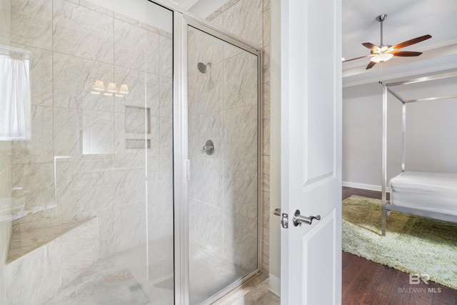 bathroom featuring wood-type flooring, a shower with shower door, and ceiling fan