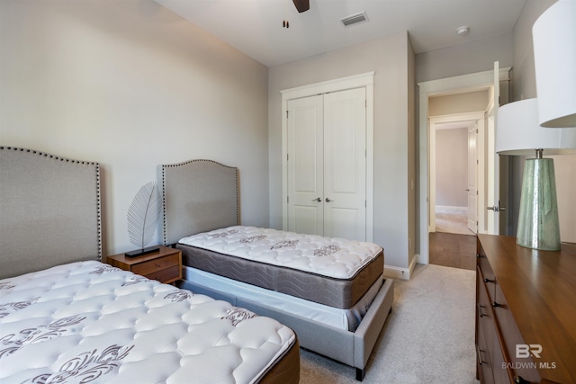 carpeted bedroom featuring ceiling fan and a closet