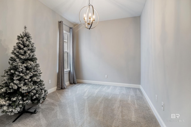 unfurnished room featuring a notable chandelier and carpet