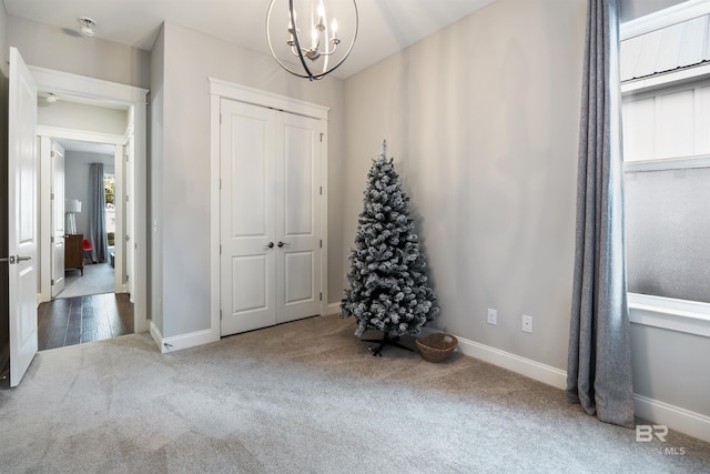 carpeted bedroom with a closet and an inviting chandelier