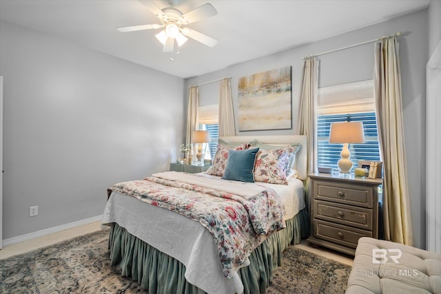 bedroom with ceiling fan and multiple windows