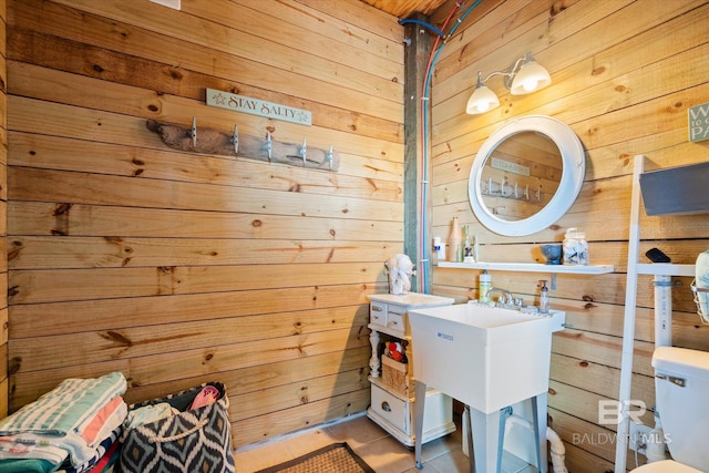 bathroom featuring tile patterned flooring, toilet, and wood walls