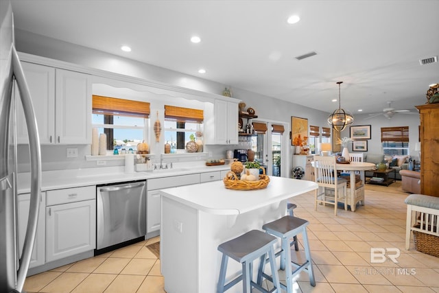 kitchen with appliances with stainless steel finishes, white cabinetry, and plenty of natural light