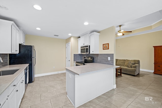 kitchen with sink, ceiling fan, stainless steel appliances, white cabinets, and kitchen peninsula