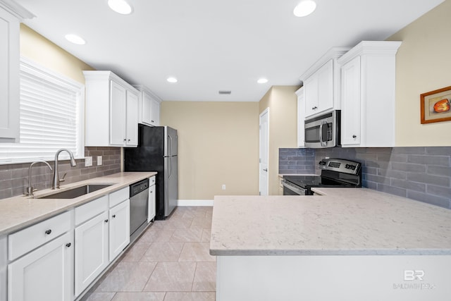 kitchen with sink, stainless steel appliances, light stone countertops, decorative backsplash, and white cabinets