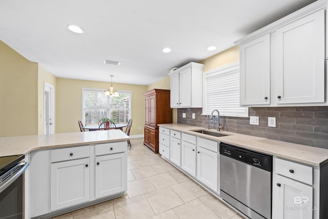 kitchen with sink, tasteful backsplash, decorative light fixtures, appliances with stainless steel finishes, and white cabinets