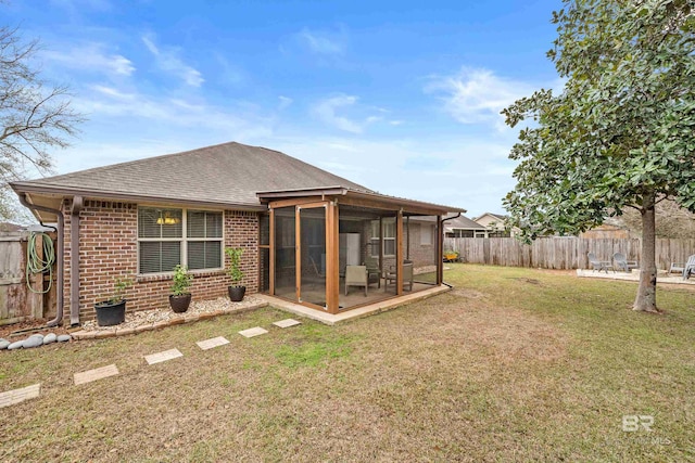 back of property with a lawn and a sunroom