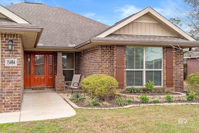 entrance to property with a patio and a lawn