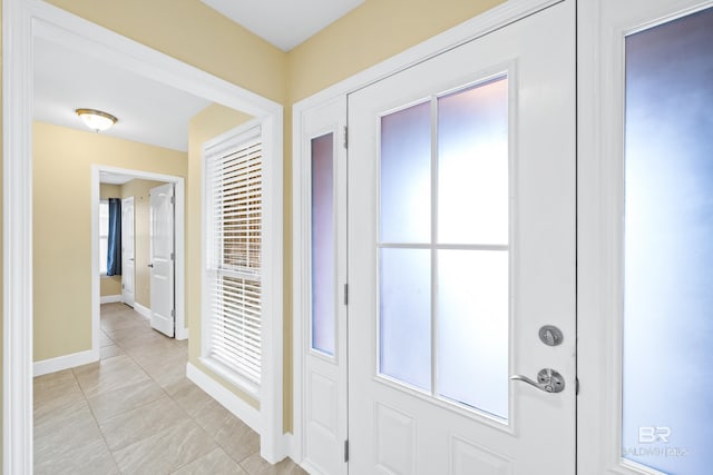 foyer entrance with light tile patterned floors and plenty of natural light