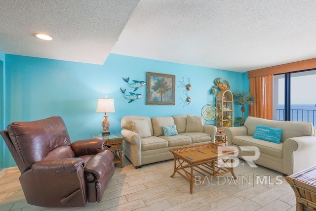 living room featuring light wood-type flooring, a textured ceiling, and a water view