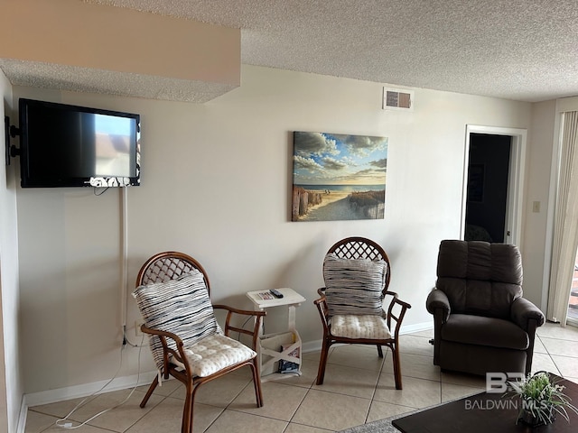 living area with light tile patterned floors and a textured ceiling