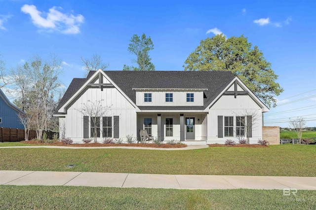 modern farmhouse with fence, roof with shingles, a porch, a front lawn, and board and batten siding