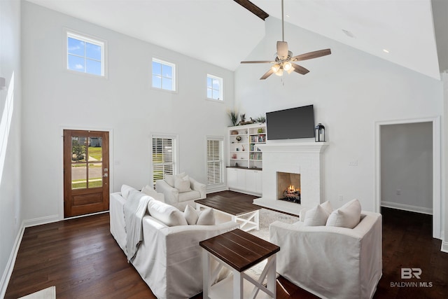 living room featuring high vaulted ceiling, dark wood-style floors, baseboards, a brick fireplace, and ceiling fan