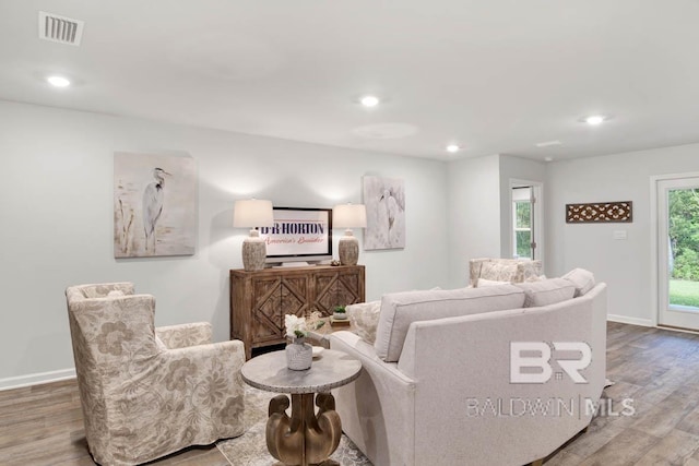 living room with recessed lighting, wood finished floors, visible vents, and baseboards