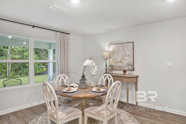 dining room with baseboards, visible vents, and wood finished floors