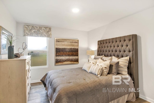 bedroom featuring baseboards and wood finished floors