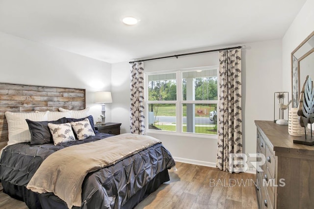 bedroom with baseboards and wood finished floors