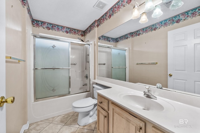 full bathroom with tile patterned flooring, vanity, toilet, and bath / shower combo with glass door