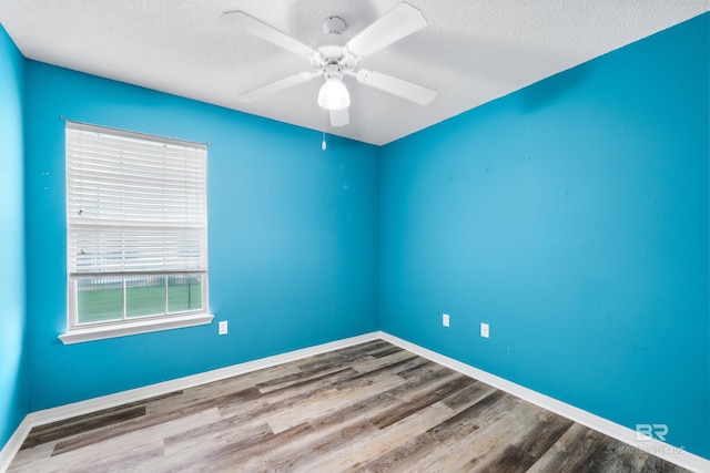 spare room featuring ceiling fan, wood-type flooring, and a textured ceiling